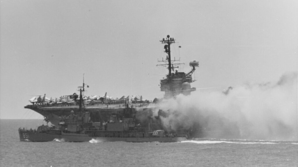 Το Αμερικανικό Αντιτορπιλικό USS Rupertus καθώς σπεύδει για βοήθεια στο φλεγόμενο Αμερικανικό Αεροπλανοφόρο USS Forrestal (CVA-59) που καίγεται ανοιχτά των ακτών του Βιετνάμ - 29/7/1967