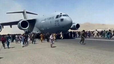 Απελπισμένοι Αφγανοί προσπαθούν να επιβιβαστούν σε μεταγωγικό της Πολεμικής Αεροπορίας των ΗΠΑ ενώ αυτό τροχοδρομεί στο αεροδρόμιο της Καμπούλ - Αύγουστος 2021