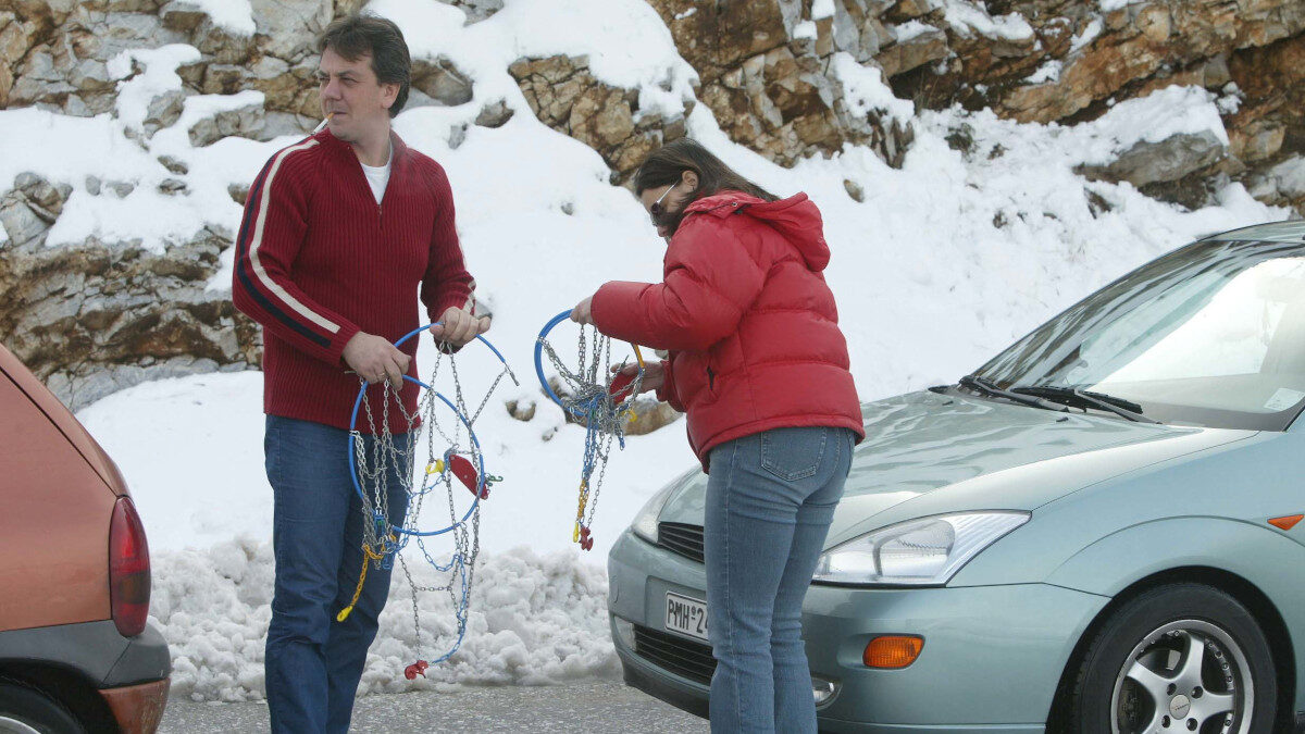 Αντιολισθητικές αλυσίδες σε αυτοκίνητα σε δρόμους που δεν έχουν καθαριστεί ακόμα από τα χιόνια