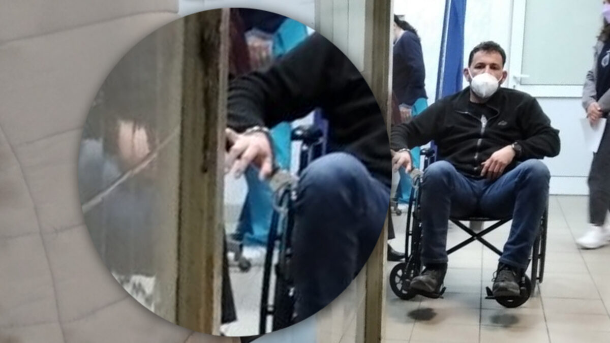 Ο Ευθύμης Δημάκης, μέλος της ΚΕ του ΚΚΕ που εξακολουθεί να νοσηλεύεται στο νοσοκομείο τραυματισμένος, με αιμάτωμα στο κεφάλι και τραύματα στο πρόσωπο. Εδώ δεμένος με χειροπέδες στο αναπηρικό καροτσάκι - 06/04/2022