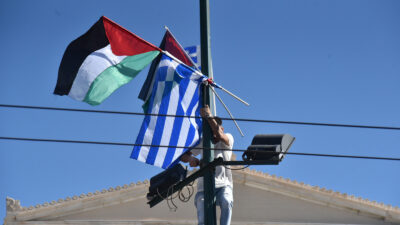 Παλαιστινιος διαδηλωτής υψώνει τις σημαίες Ελλάδας - Παλαιστίνης στο Σύνταγμα